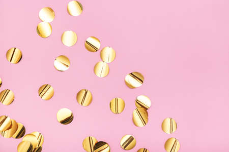 Close up of gold metallic confetti on pastel pink background. Top view.の写真素材