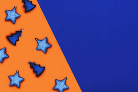 Flat lay with Christmas toys on orange and blue background.の写真素材