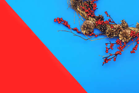 Flat lay with Christmas wreath on blue and red background with copy space.の写真素材