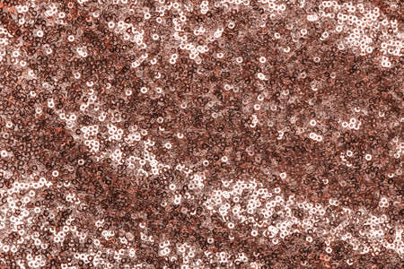 Sparkling rose gold sequins textile background.