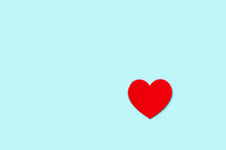 Red decorative heart on a blue background. Valentine's day background in minimal style.