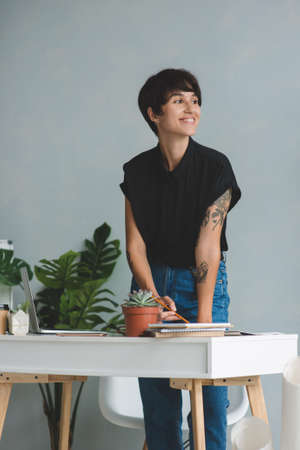 Young business woman standing near the desk in modern office.