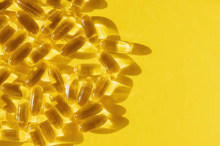 Fish oil capsules on yellow backgroundの写真素材