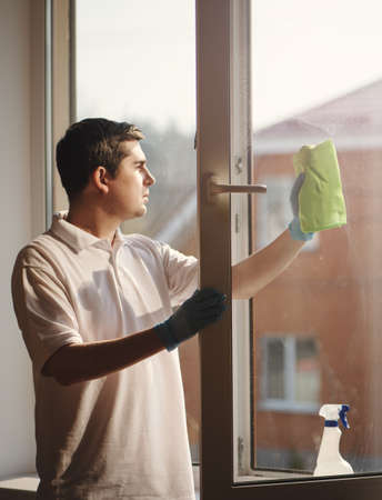 Man cleaning window with spray and sponge.の写真素材