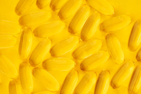 Fish oil capsules on yellow backgroundの写真素材