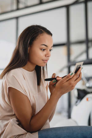 Young African-american woman doing makeup.の写真素材