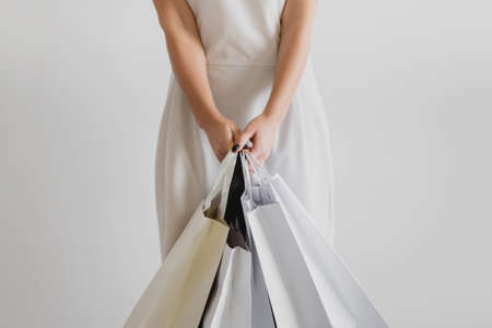 Cropped image of woman holding shopping bags on white background.の写真素材