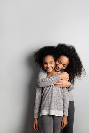 Portrait of mother embracing her daughter from behind.の写真素材