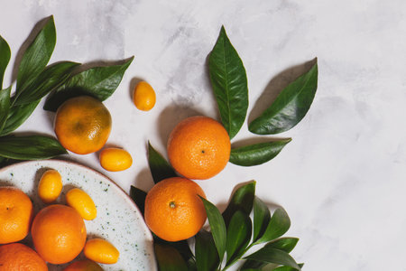 Citrus fruit with green leaves in a white plate.