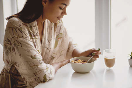 Close up of African American female eating granola with berries.の写真素材