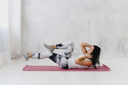 Attractive woman practicing exercise for abs indoors.の写真素材