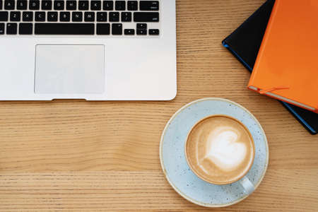 Wood office desk table with laptop, coffee cup and notebook.の写真素材