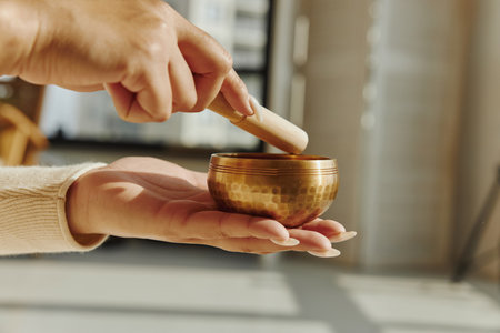 Closeup of woman hands using singing bowl in sound healing therapy.の写真素材