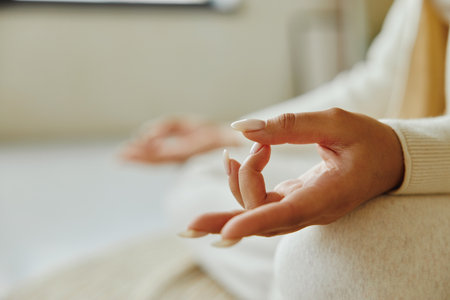 Closeup of young woman hand while sitting in lotus position and meditating.の写真素材