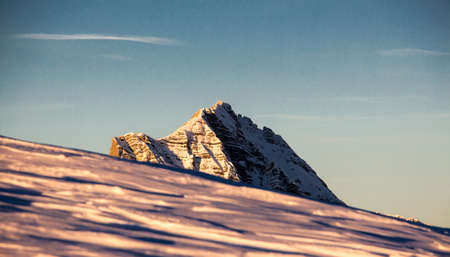 Mountain portrait Birnhorn Saalbach sunset purple light clouds snowy mountainの写真素材