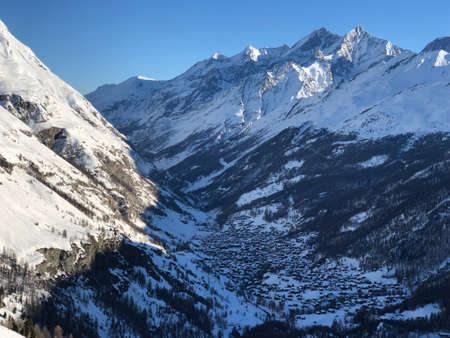 Perfect view of the Mattertal and surrounding mountains like weisshorn in Zermatt sunset view, with blue sky and perfect light. The snowy Swiss mountains and landscape in winter is extraordinary. After a long skiing day these views are incredible.の素材 [FY310137960601]