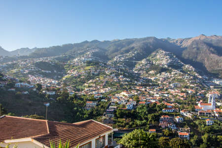 Beautiful madeira spectacular landscape with the typical white buildings and hutts up the hills of the high mountains. Sunny day blue sky perfect outdoor travel madeira conceptの写真素材