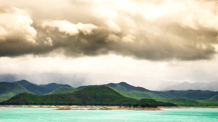 The green of the back is a green mountain with a large rain cloud.の写真素材