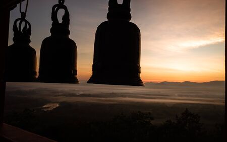 The sun's image is going up into the sky and is shining in orange, causing the things to change into shadows.の写真素材