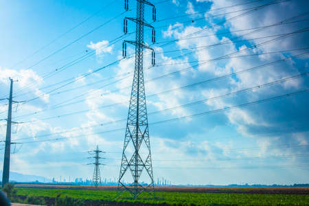 High-voltage power tower line on green field