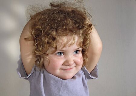 Happy curly baby with blue eyesの写真素材