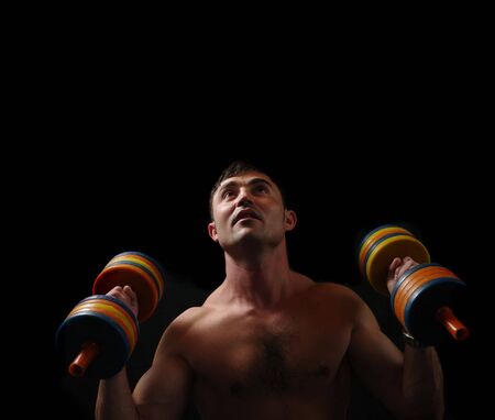 young man lifting dumbbellsの写真素材
