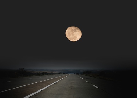 Highway passing through desert in moon light 