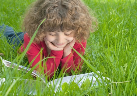 Girl reading a book on the grass の写真素材