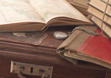 antique background with the old map and a clock on a wooden tableの写真素材