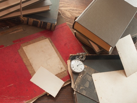 antique background with the old map and a clock on a wooden table 