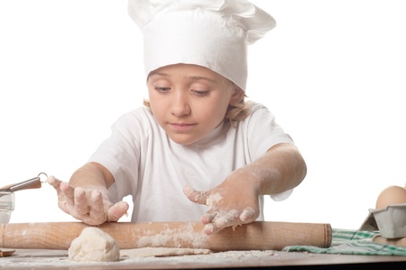 photo of little baker adorable, pretty little caucasian girl in chef hat. Cooking concept.の写真素材