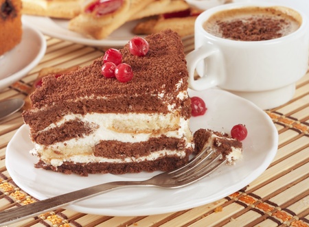 Close-up of white cup of coffee and chocolate cake 
