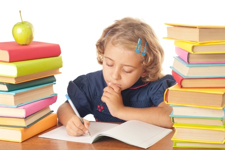 Blonde happy schoolgirl works on her homework, write something in her notepad, isolated on white の写真素材