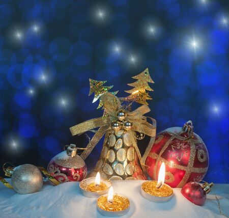 Burning candles in a Christmas setting with seasonal decorations の写真素材