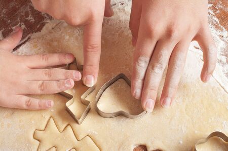 little girls and mother cutting christmas gingerbread cookies, hands only 