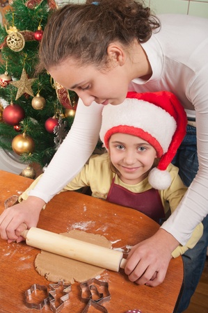 mother and daughter baking Christmas cakes in the kitchen の写真素材