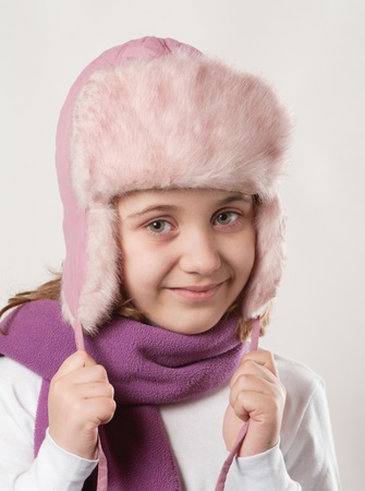 Cute little happy girl posing in a fur hat. の写真素材