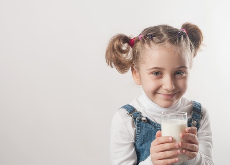 Cute little girl drinks milk の写真素材