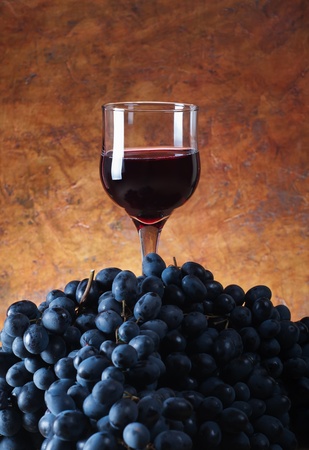 glass of wine on a pile of grapesの写真素材