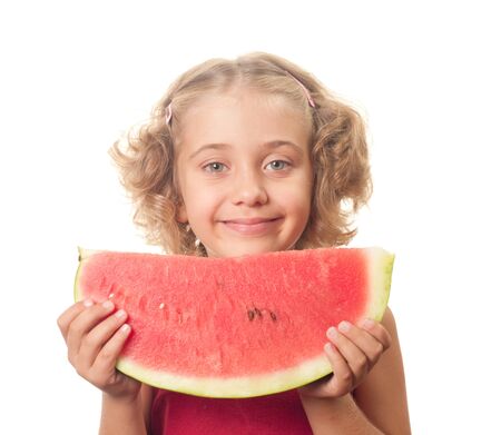 Little smiling girl eating watermelon の写真素材