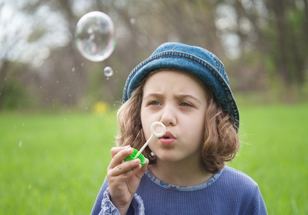 Little girl blowing soap bubblesの写真素材