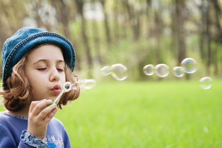 Little girl blowing soap bubblesの写真素材