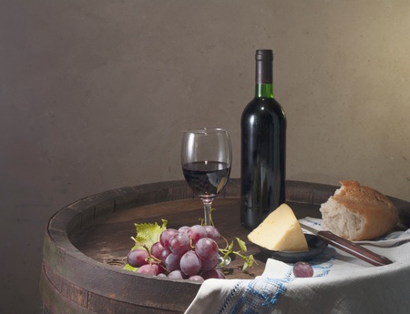 Red wine, assorted cheeses, bread and grapes in a still life setup  の写真素材