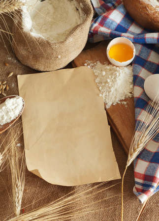 bread, eggs and flour a sheet of paper for the recipeの写真素材