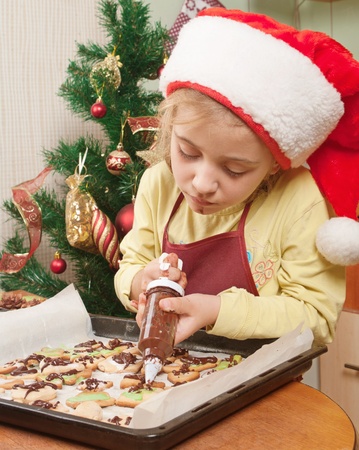 Little girl decorating the christmas cookies の写真素材