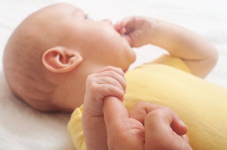 Baby hold mother finger on your hand 