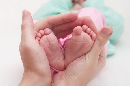 Newborn baby feet in motherの写真素材