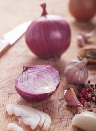Closeup of onions and peppercorns on an old wooden tableの写真素材