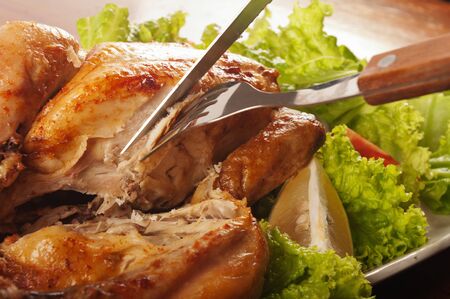 knife cut through the roast chicken の写真素材