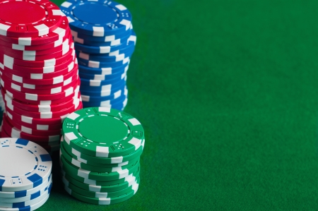 Poker chips on green  background with place for sample textの写真素材